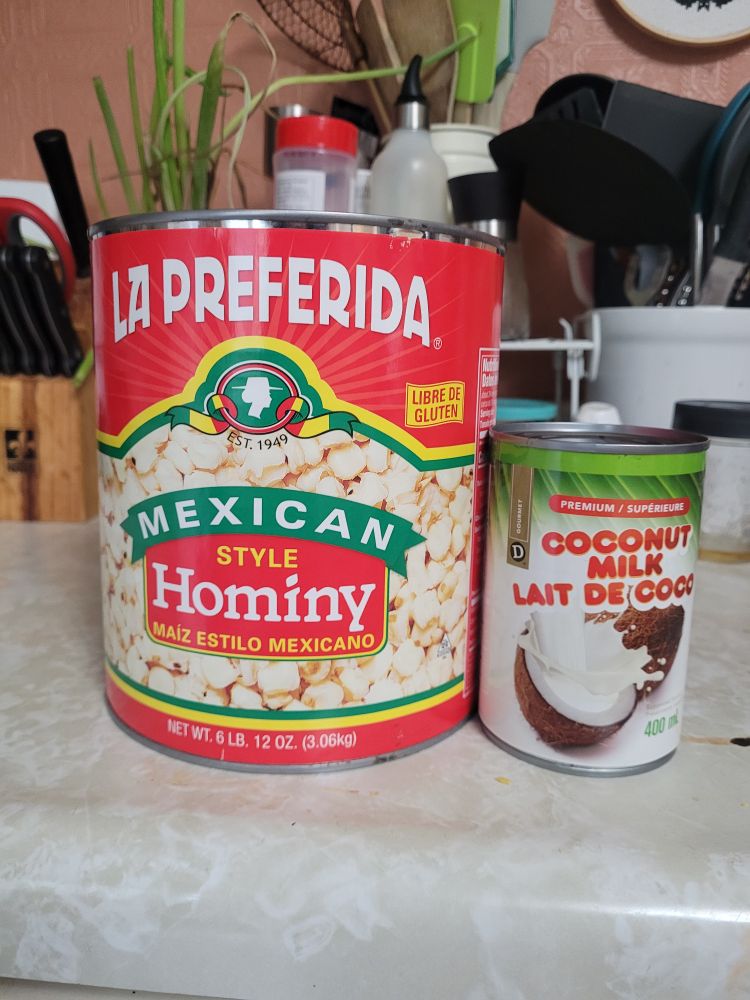 The comically large can of hominy next to a normal 400ml can of coconut milk