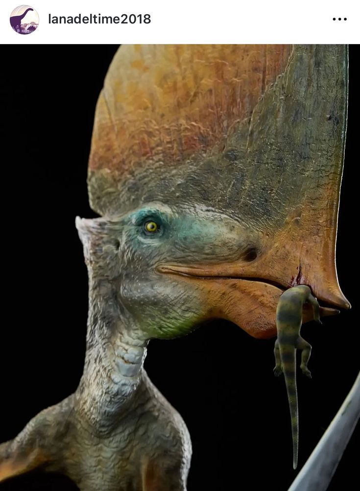 Close up of a pterosaur’s face eating a lizard