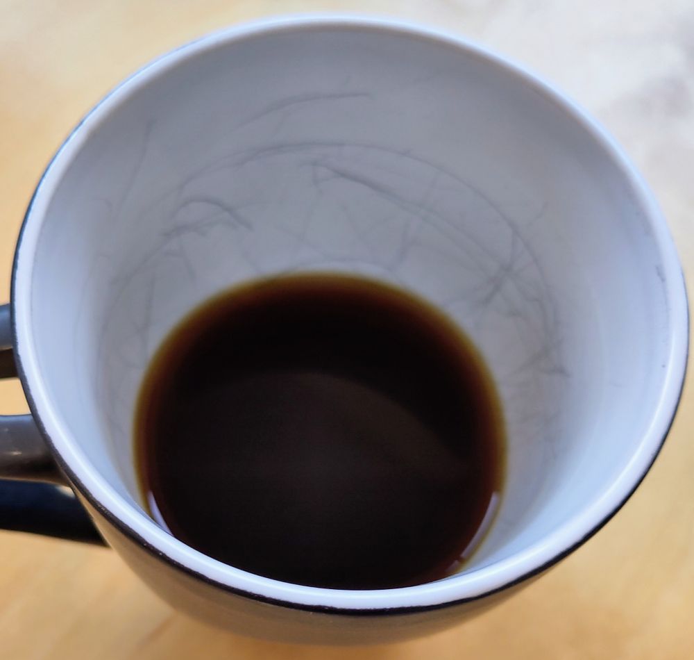 Ein schwarzer Kaffee, pour over 6/100, bio, in einer etwas länger schon verwendeten Tasse. Abgenutzt und trotzdem schön.