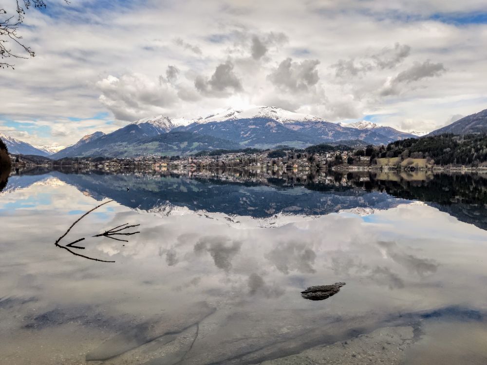 Spiegelglatter Millstätter See. Zu sehen sind die Ortschaft Seeboden und die Nockberge in den Alpen in Kärnten.
