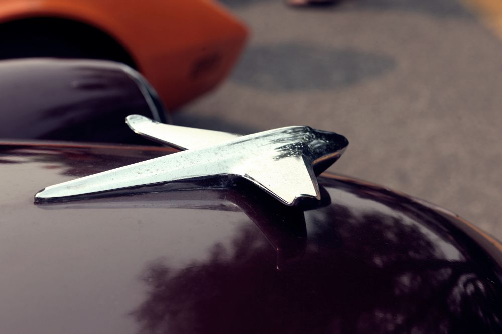 old car hood ornament shaped like an airplane 