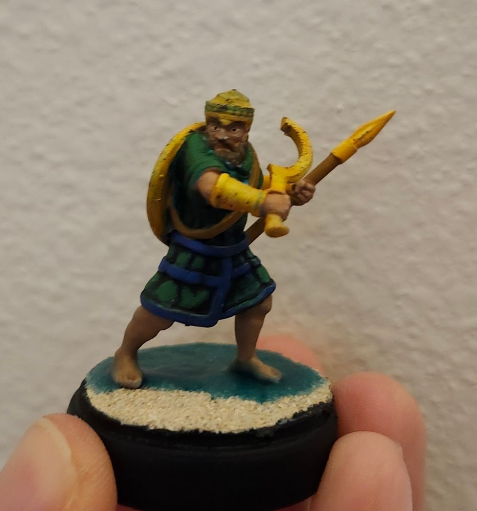 A Sea Peoples' soldier standing in shallow water on a beach shore, wielding a spear and khopesh