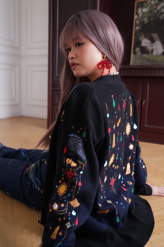 Model wearing black cardigan with jewels shaped embroideries on the back