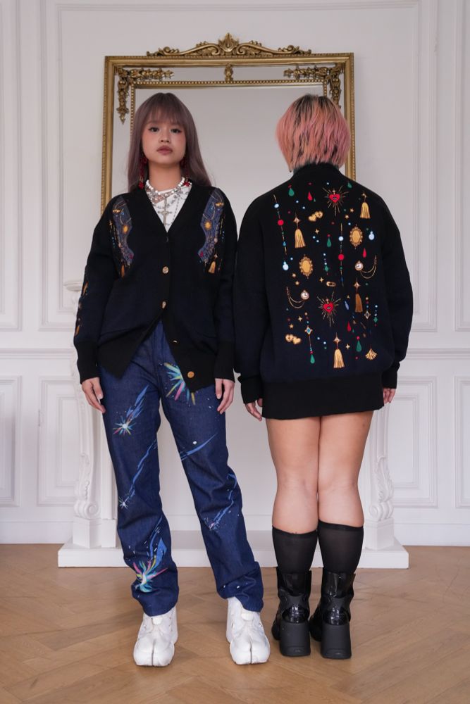 Models wearing black cardigans with colorful jewelry shaped embroideries. 