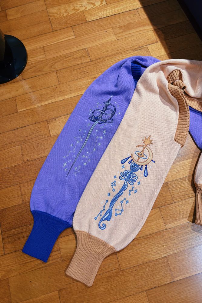 Photo of two boleros/shrugs, each with rapier and magic staff shaped embroideries
