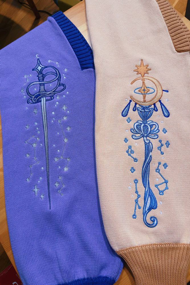 Close up of knit bolero sleeves with sword and magic staff shaped embroideries 
