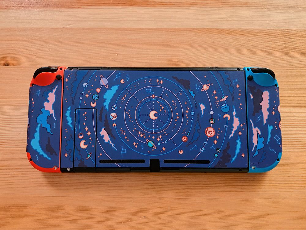 Switch console back covered with blue decals with artwork of the moon surrounded by orbiting stars, planets, and nebulae
