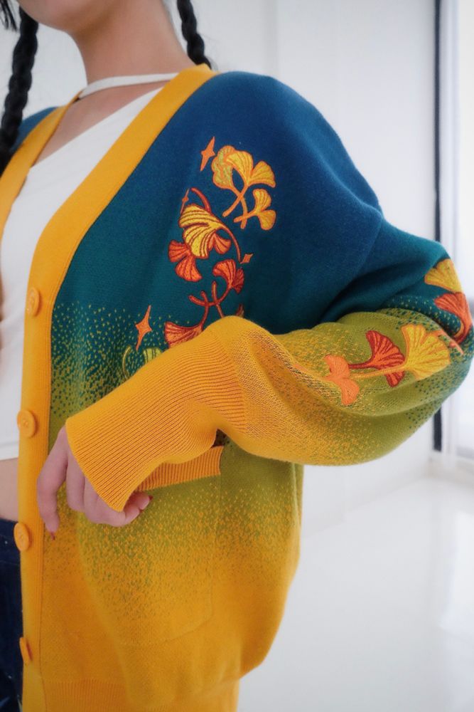 Model wearing blue, green, and yellow gradient cardigan with ginkgo embroideries. 