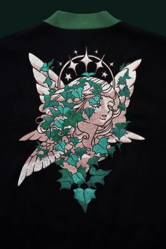 Black and green cardigan with embroidered angel statue covered with ivy plant. 