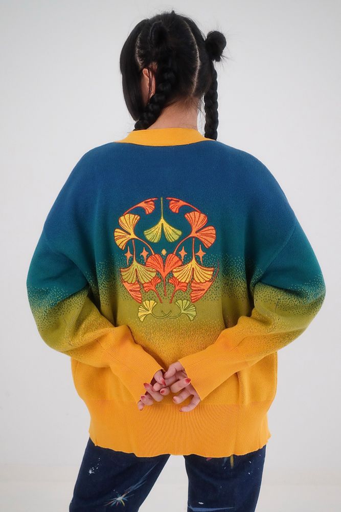 Model wearing blue, green, and yellow gradient cardigan with ginkgo embroideries on the back. 