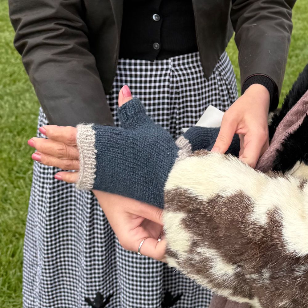 Dark blue stockinette fingerless mitts with light grey 1x1 rib edging. 