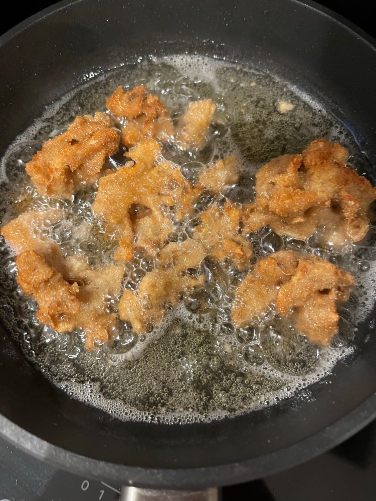 Paniert werdende Stücke in der Pfanne 