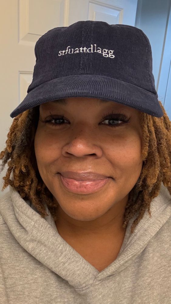 cara in a blue corduroy hat that says stfuattdlagg 