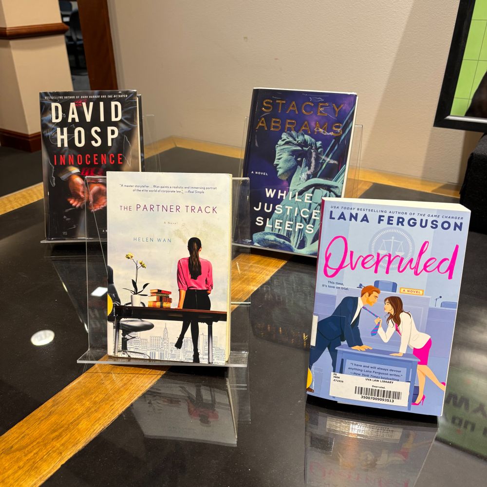 Four books. Innocence by David Hosp, The Partner Track by Helen Wan, While Justice Sleeps by Stacey Abrams, and Overruled by Lana Ferguson.

