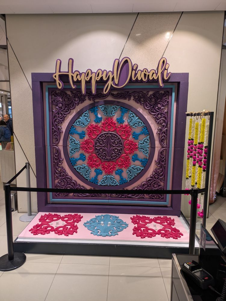 Colourful display of blue red and purple  in the appearance of a rangoli saying happy Divali 