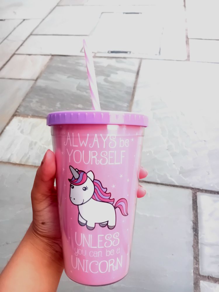 me holding a pink cup with the text "always be yourself unless you can be a unicorn" written on it and a cute white unicorn with a pink and purple mane and a purple lid and pink and white striped straw