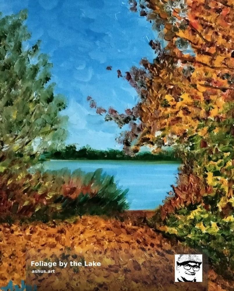 A scene from Germany of bright orange and yellow foliage, with the background of blue lake and misty skies