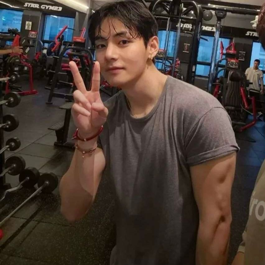 Taehyung in a gym pic. He's very cute from the neck up. Cute little V sign held up next to his puppy eyes. From the neck down, he's all bulging arm muscles and tasty arm veins.