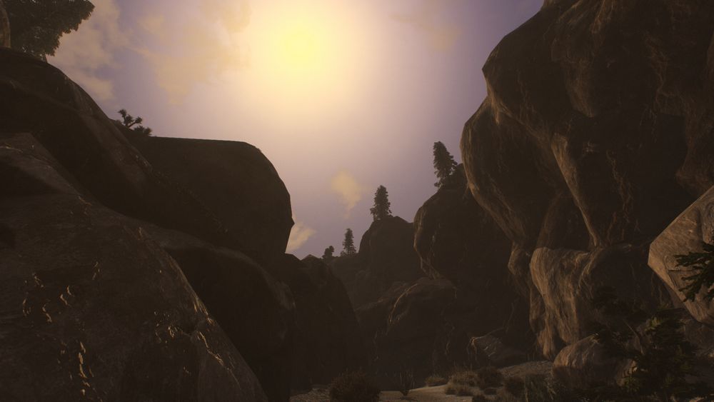 The caverns of Potasi Pass flank the shot as the sun rests above. Trees and desert vegetation dot the Pass. 