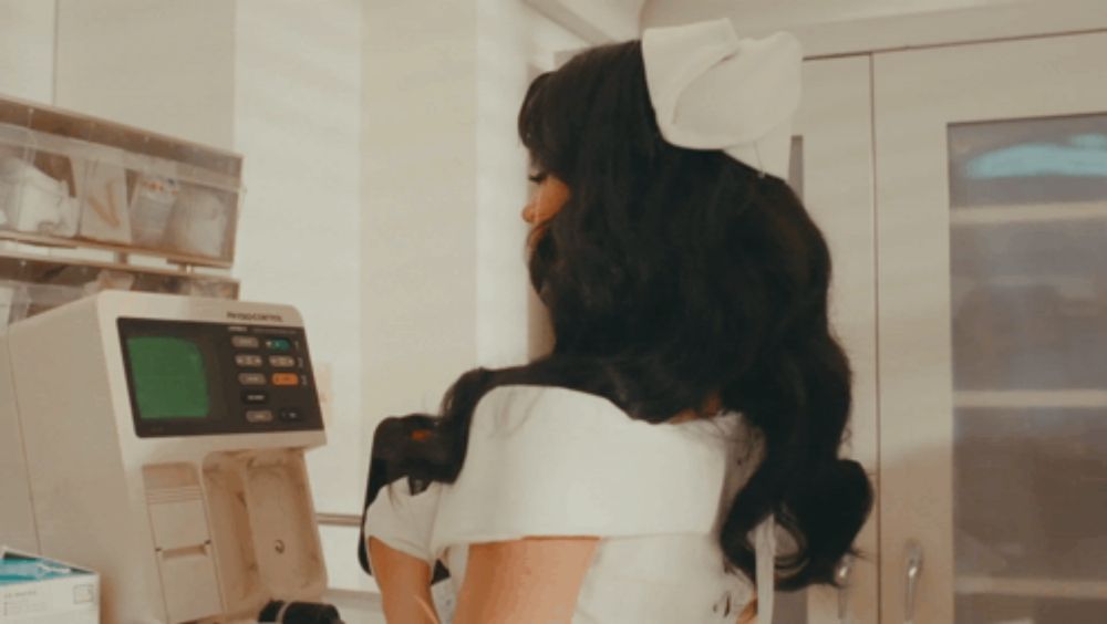 a woman in a nurse 's outfit is looking at a machine that says biocontrol on it