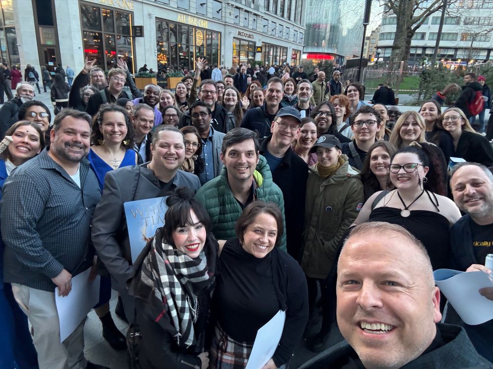 This a selfie Innkeeper Hatch took outside the WoT S3 fan screening at the Odeon next to The Londoner hotel in Leicester Square. Behind everyone is a building with a a bar and restaurants. In the picture are around 50 fans smiling at the camera. In the very front are The Innkeeper’s Wife and Sarah Nakamura. 