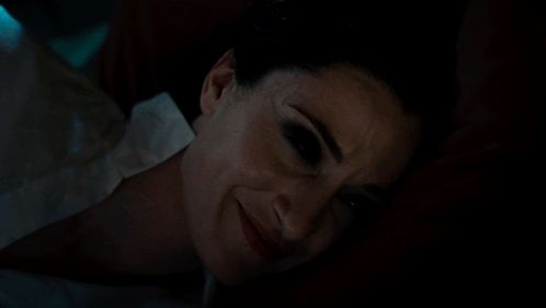 a woman laying down with her eyes closed and a smile on her face