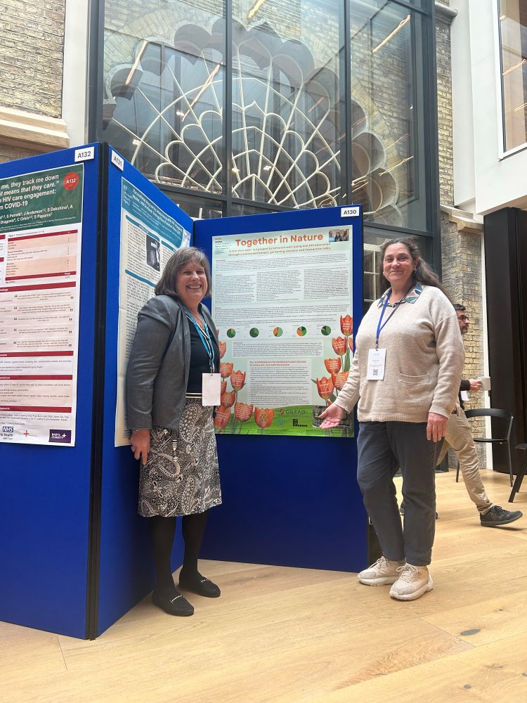 2 beautiful women standing by a poster abstract for the British HIV Association spring conference held at The dome in Brighton, poster reads together in Nature 