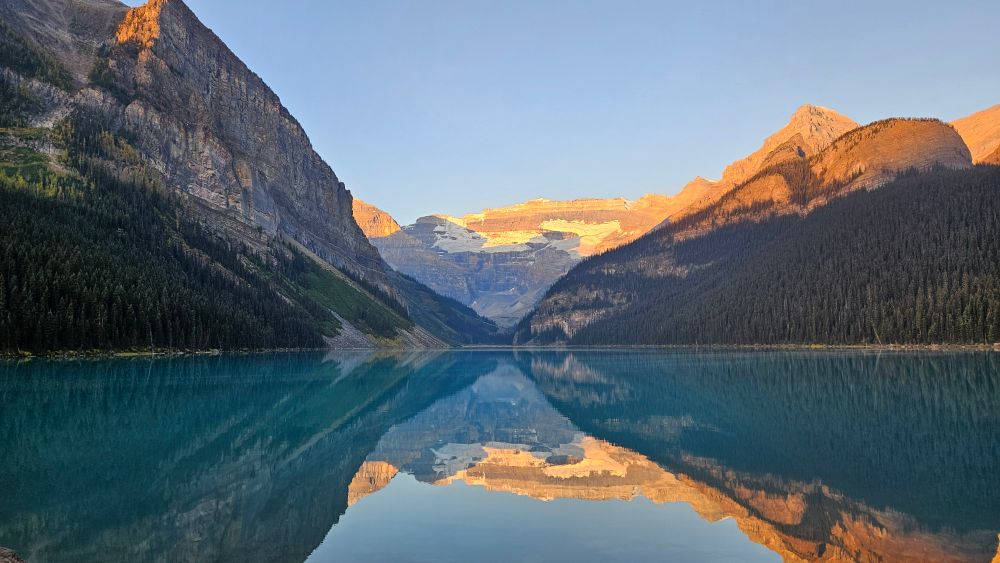 Lake Louise at sunrise, the sun painting the glaciers golden