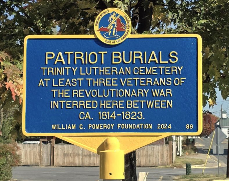 Patriot Burials marker inscribed with Trinity Lutheran Cemetery at least three veterans of the Revolutionary War interred here between CA. 1814–1823. 