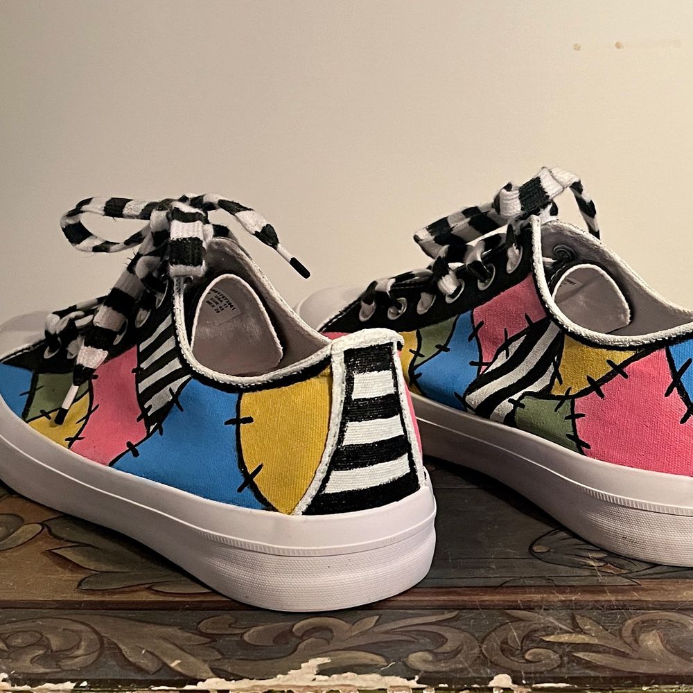 Handpainted sneakers using pastel pink, pastel green, light blue and bright yellow, with accents of black and white pinstripes and black stitches