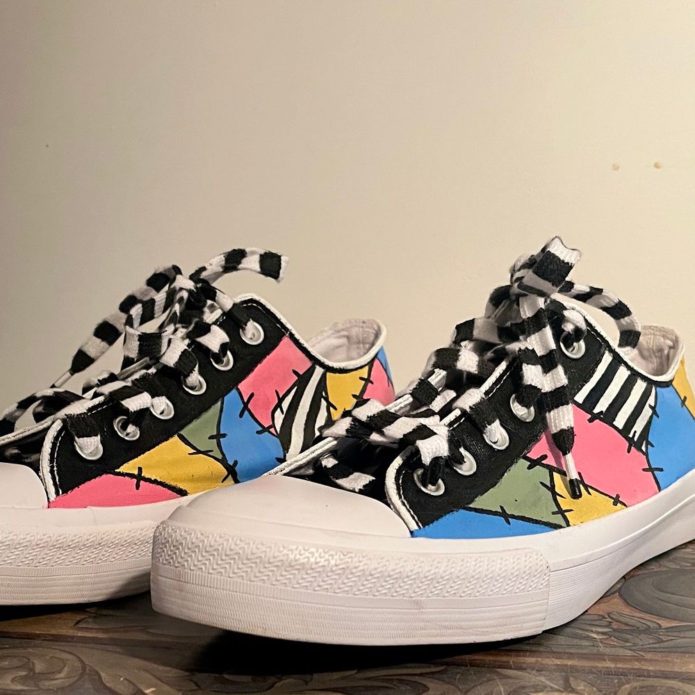 Handpainted sneakers using pastel pink, pastel green, light blue and bright yellow, with accents of black and white pinstripes and black stitches