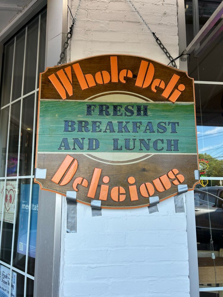 While deli store sign hanging by a chain and re-positioned with duct tape