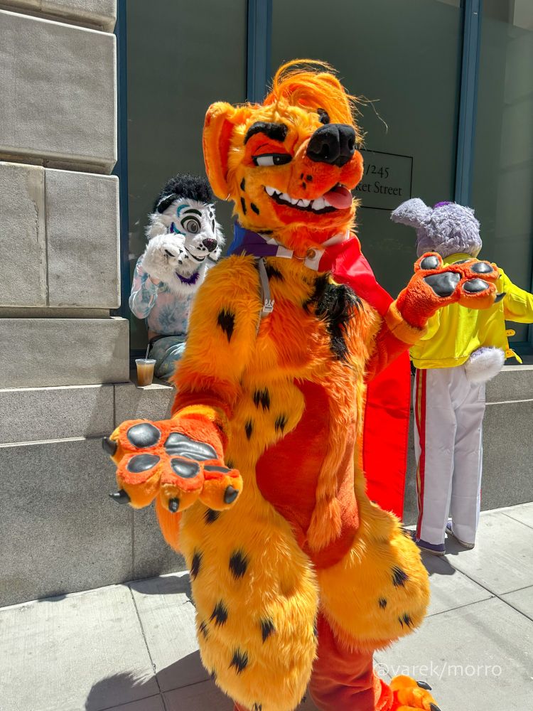 San Francisco Pride, street scene. Photo of fiery orange/red spotted hyena fursuiter aptly named Fuego. 