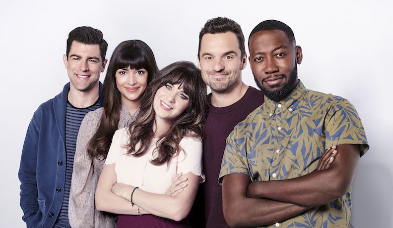 The cast of new girl in front of a white backdrop 