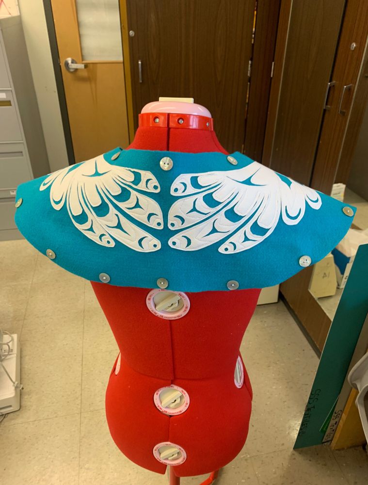 A picture of the previous felt collar on a red sewing dummy, but from the back. It shows the tail of the grouse.