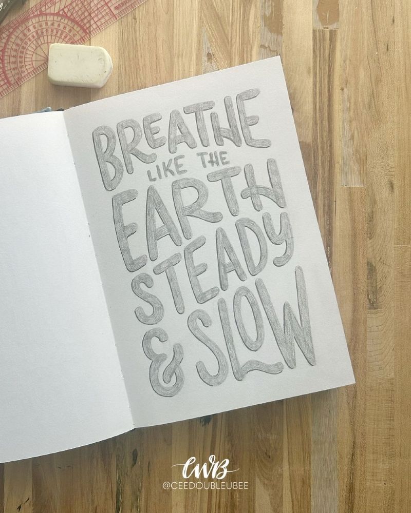 Hand lettered sketchbook page featuring the quote “breathe like the earth, steady and slow” in pencil lettering with natural flow and soft edges.