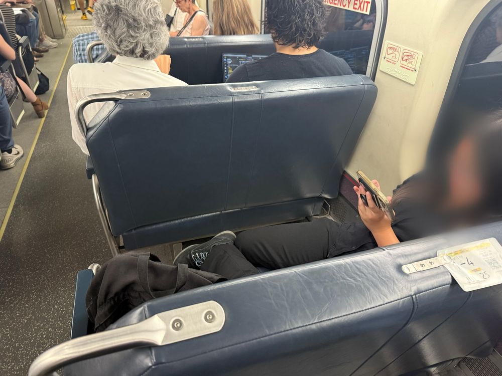 Rude idiot hogging double seats on a crowded train 