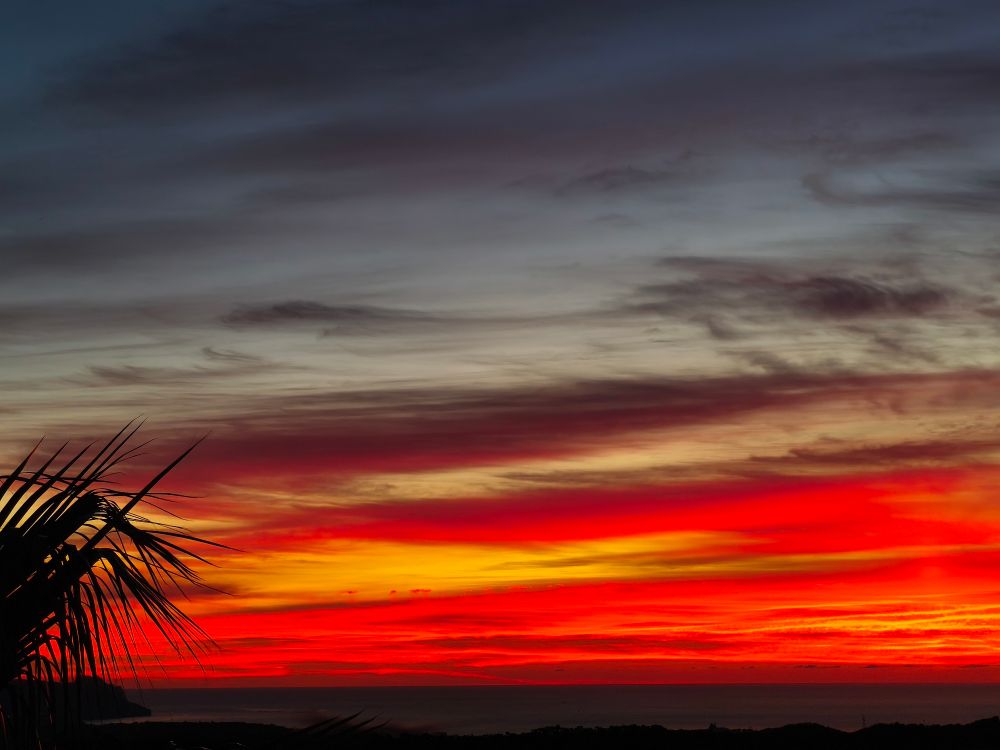 The sun rises over the western Mediterranean in citrus stripes interspersed with charcoal clouds. Taken on the Costa Blanca, Spain.