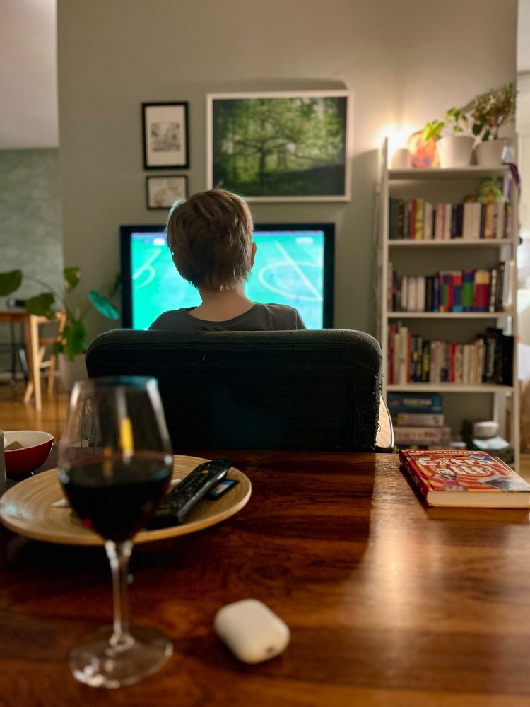 Nacken på ett barn som sitter framför en tv och spelar Fifa23.