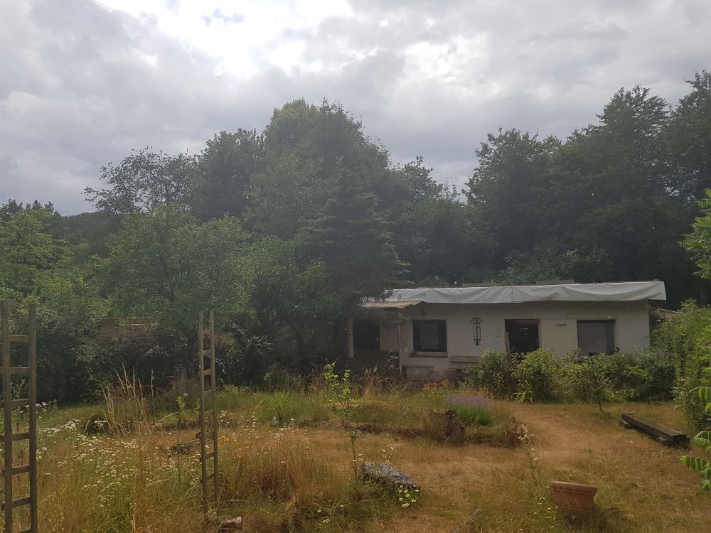 das Foto zeigt unseren Garten mit dem Kleinen Häuschen im Hintergrund.