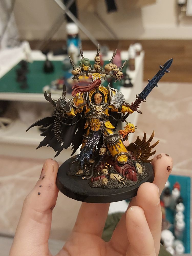Abbadon the Despoiler, his armour is painted yellow, with his tabard painted black with stars on it. He is standing on a red and bone painted Blood Raven space marine.