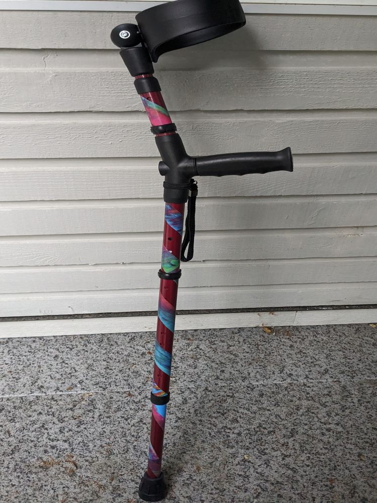 Picture of Red Forearm crutch with rainbow stripes.