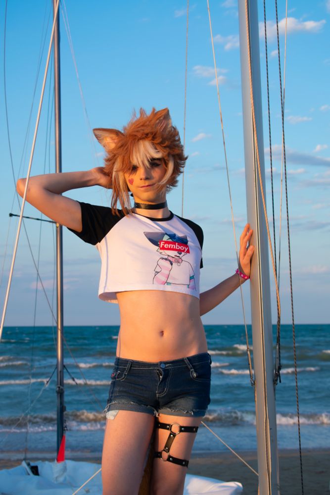 Picture of me cosplaying as Gorou from Genshin impact in a femboy casual version, resembling a sailor. Standing on a boat on a beach, showing off my tummy waist and thighs 