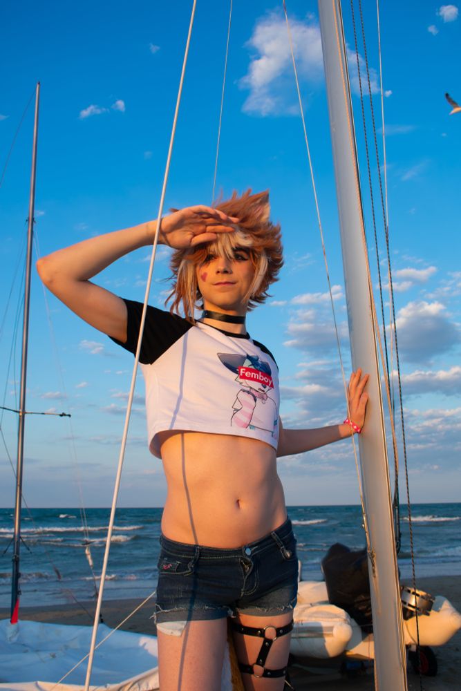 Picture of me cosplaying as Gorou from Genshin impact in a femboy casual version. I have my tummy and waist exposed by my cute small crop top and shorts revealing my thighs. 

In the picture I'm leaning against a pole from a small boat, and I'm looking away from the camera while protecting my eyes from the sun.

The picture is fully colored 