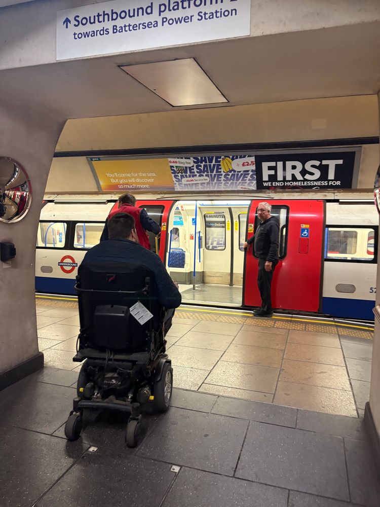 Nathan heading towards a northern line train in his power chair. 