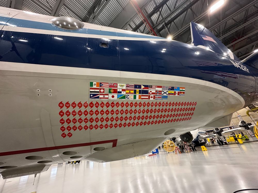 Decals on the side of a NOAA plane showing country flags and hurricane icons. These show the countries and storms the plane has operated in.