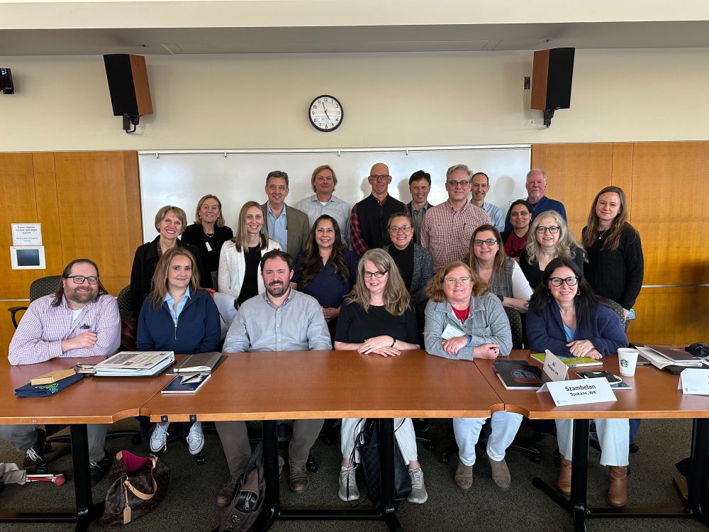 A group of people sit and stand for a photo in a conference room. Credit: Washington State Administrative Office of the Courts