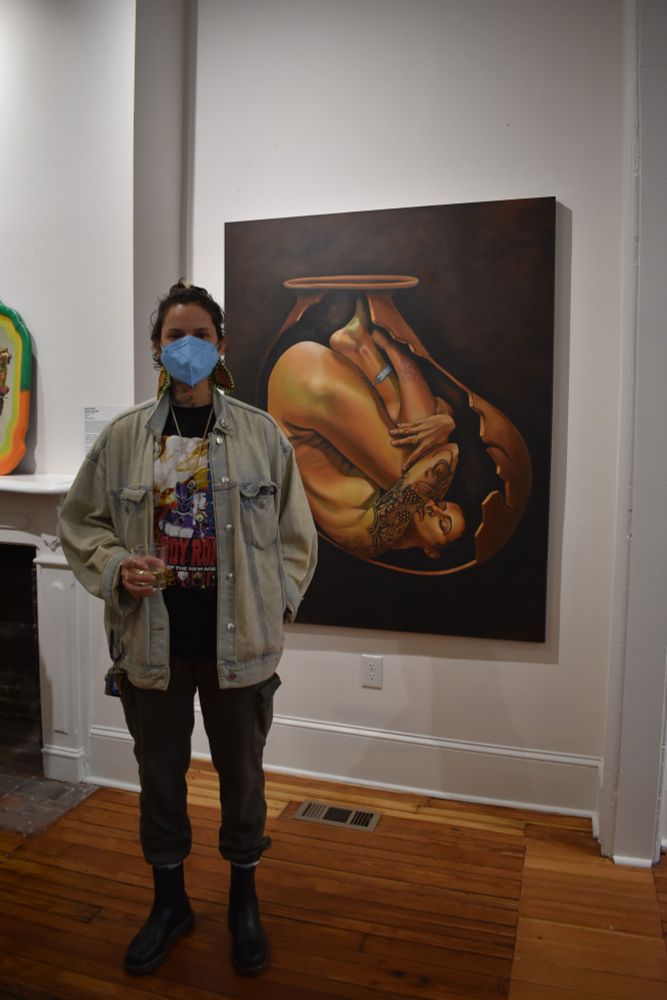 Jessy de Santis poses with their piece "Return to the Land" this work is available for sale.