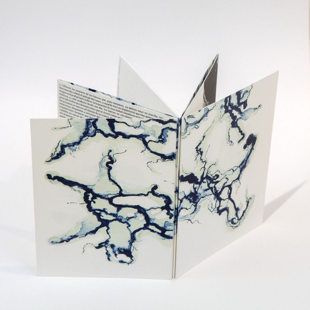 An open book with an abstract, marbled pattern of black and white swirls and textures covering the pages.