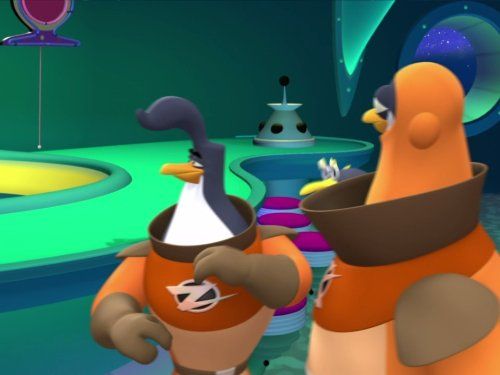 Scene from 3-2-1 Penguins!, a children's animated sci-fi series featuring spacefaring penguins teaching moral and scientific lessons. The image shows Zidgel and Kevin, two main penguin crew members aboard the S.S. Penguin, wearing orange space uniforms with the show's lightning bolt emblem. The vibrant spaceship control room glows with teal and purple tones, highlighting the series’ colorful 3D animation style. 3-2-1 Penguins! was created by Big Idea, the studio behind VeggieTales, and blends faith-based values with educational adventures in space. Popular among early 2000s viewers, the show introduced basic science themes like gravity, inertia, space travel, and problem-solving through episodic missions. This image captures the show's lighthearted tone, futuristic setting, and character-driven storytelling that made it a favorite for young fans interested in outer space and character lessons.

